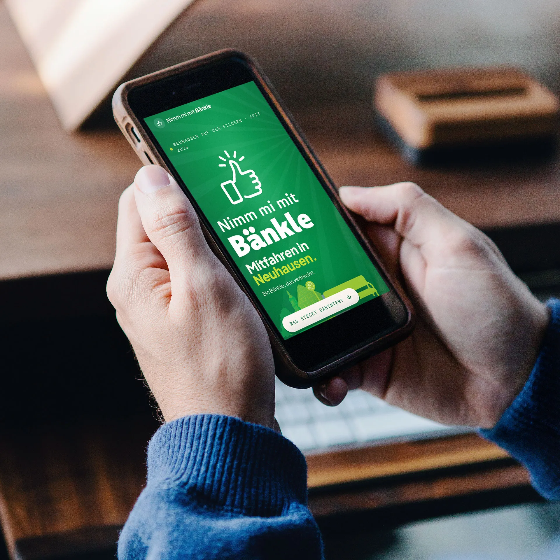Smartphone mit mobiler Website der Mitfahrinitiative „Nimm mi mit Bänkle“ in Neuhausen auf den Fildern. Die responsive Webseite informiert über Mitfahrbänke und fördert nachhaltige Mobilität sowie nachbarschaftliche Unterstützung.